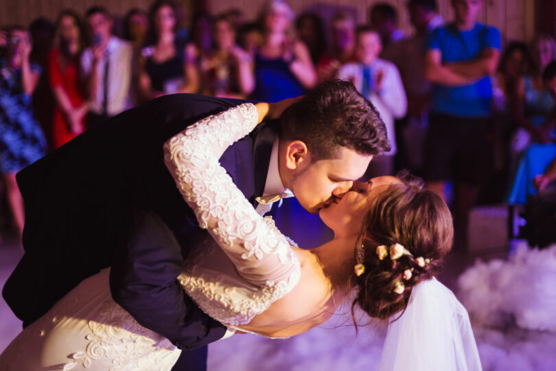 Groom,Kisses,Bride,While,Bending,Over,During,Their,First,Dance