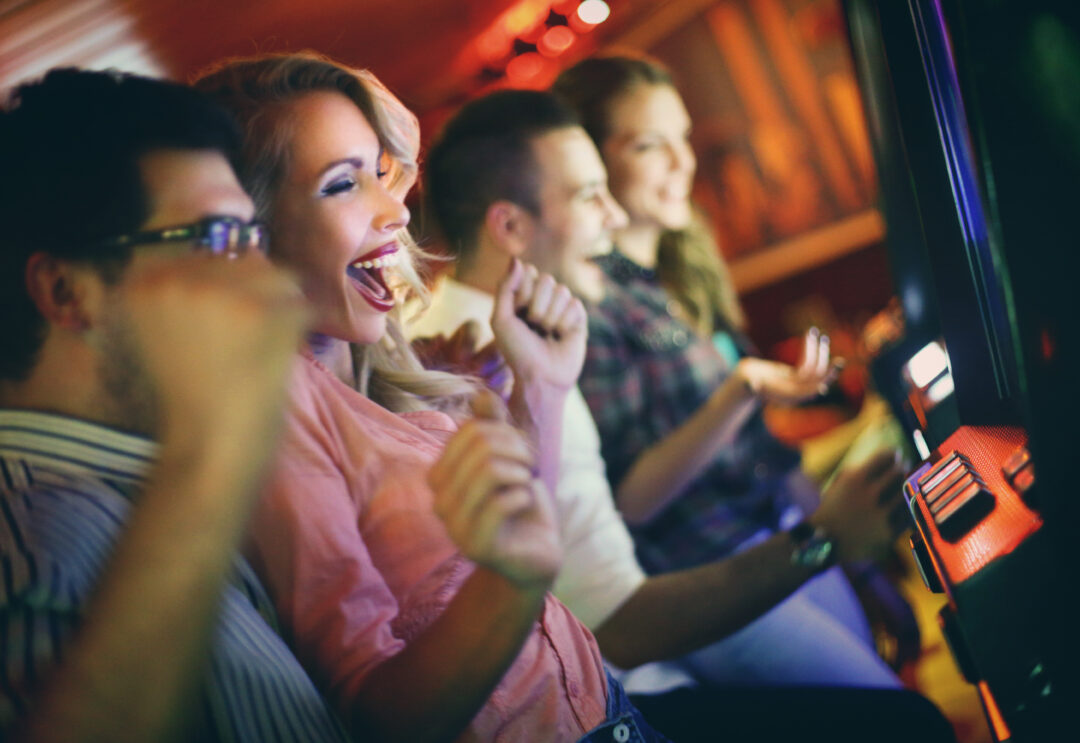 Grupo de personas jugando tragamonedas en el casino.