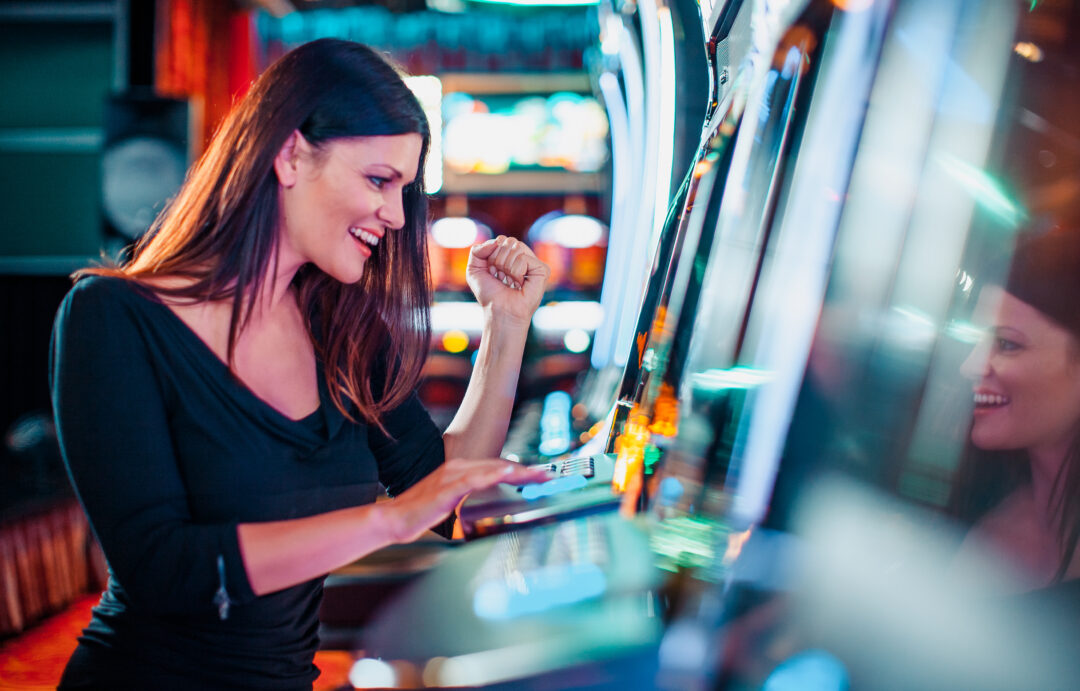 Mujer elegante ganando en una máquina tragamonedas